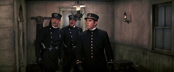 Movie still from “The Molly Maguires” (1970), directed by Martin Ritt – A group of men standing next to each other wearing uniforms; Medium shot, Low angle