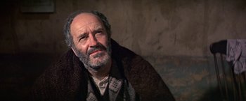 Movie still from “The Molly Maguires” (1970), directed by Martin Ritt – An older man sitting on a couch with a blanket around his neck; Close Up shot, Low angle