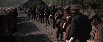 Movie still from “The Molly Maguires” (1970), directed by Martin Ritt – A group of men standing next to each other on a dirt road; Medium shot, High angle