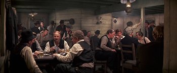 Movie still from “The Molly Maguires” (1970), directed by Martin Ritt – A group of men sitting at a table in a room; Wide shot, High angle