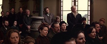 Movie still from “The Molly Maguires” (1970), directed by Martin Ritt – A group of men and women sitting in front of a fireplace; Medium shot, Over the shoulder angle