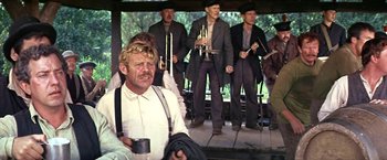 Movie still from “The Molly Maguires” (1970), directed by Martin Ritt – A group of men standing next to each other on a porch; Medium shot, Low angle