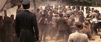 Movie still from “The Molly Maguires” (1970), directed by Martin Ritt – A group of men standing next to each other on a dirt road; Wide shot, Over the shoulder angle
