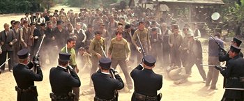 Movie still from “The Molly Maguires” (1970), directed by Martin Ritt – A group of men in uniform holding baseball bats in a field; Wide shot, High angle