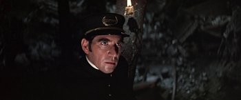 Movie still from “The Molly Maguires” (1970), directed by Martin Ritt – A man wearing a uniform and a hat looking to his left; Close Up shot, Low angle