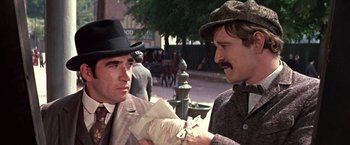 Movie still from “The Molly Maguires” (1970), directed by Martin Ritt – Two men in suits and hats talking on the sidewalk; Close Up shot, Over the shoulder angle