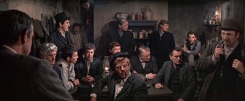 Movie still from “The Molly Maguires” (1970), directed by Martin Ritt – A group of people sitting around a table; Medium shot, High angle