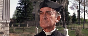 Movie still from “The Molly Maguires” (1970), directed by Martin Ritt – An older man wearing a priest's outfit; Close Up shot, Low angle