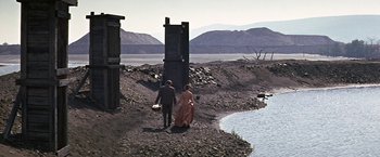 Movie still from “The Molly Maguires” (1970), directed by Martin Ritt – A man and a woman walking along side of a river; Extreme Wide shot, High angle