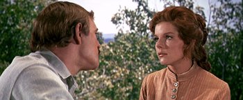 Movie still from “The Molly Maguires” (1970), directed by Martin Ritt – A man and a woman face to face in front of trees; Close Up shot, Over the shoulder angle
