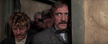 Movie still from “The Molly Maguires” (1970), directed by Martin Ritt – A group of men standing next to each other in a room; Close Up shot, Low angle