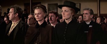 Movie still from “The Molly Maguires” (1970), directed by Martin Ritt – Two women and a man are standing in a crowd; Close Up shot, Low angle