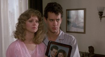 Movie still from “The Money Pit” (1986), directed by Richard Benjamin – A man and a woman holding a picture of a man and a woman; Close Up shot, Over the shoulder angle