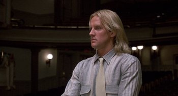 Movie still from “The Money Pit” (1986), directed by Richard Benjamin – A man with long blonde hair wearing a shirt and tie; Close Up shot, Low angle