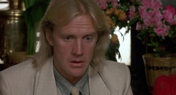 Movie still from “The Money Pit” (1986), directed by Richard Benjamin – A person wearing a suit and tie; Close Up shot, Over the shoulder angle