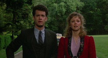 Movie still from “The Money Pit” (1986), directed by Richard Benjamin – A man and a woman standing next to each other in front of trees; Close Up shot, Low angle