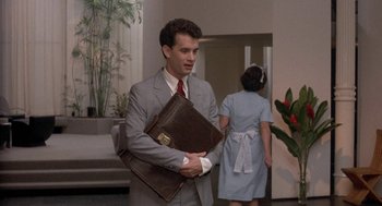 Movie still from “The Money Pit” (1986), directed by Richard Benjamin – A man in a suit holding a briefcase; Medium shot, Low angle