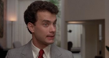 Movie still from “The Money Pit” (1986), directed by Richard Benjamin – A man in a gray suit and a red tie; Close Up shot, Over the shoulder angle