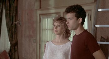 Movie still from “The Money Pit” (1986), directed by Richard Benjamin – A man and a woman standing next to each other in a room; Medium shot, Low angle