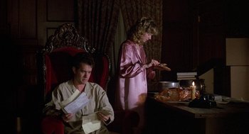 Movie still from “The Money Pit” (1986), directed by Richard Benjamin – A man and a woman sitting at a dinner table; Medium shot, High angle