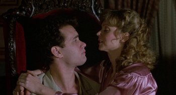 Movie still from “The Money Pit” (1986), directed by Richard Benjamin – A man and a woman are kissing on the cheek; Close Up shot, Overhead angle