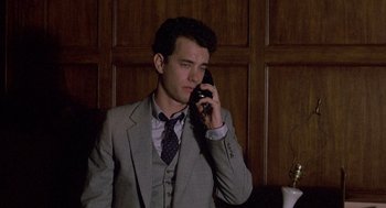 Movie still from “The Money Pit” (1986), directed by Richard Benjamin – A man in a suit and tie talking on a cell phone; Medium shot, Low angle