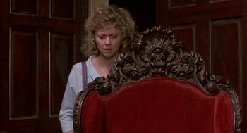 Movie still from “The Money Pit” (1986), directed by Richard Benjamin – A woman standing in front of an ornate chair; Medium shot, Over the shoulder angle