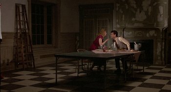 Movie still from “The Money Pit” (1986), directed by Richard Benjamin – A man and a woman sitting at a dinner table; Wide shot, High angle