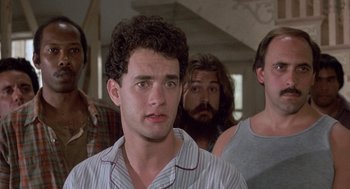 Movie still from “The Money Pit” (1986), directed by Richard Benjamin – A group of men standing next to each other in a room; Close Up shot, Low angle