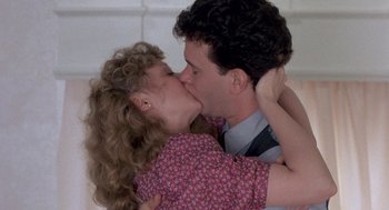 Movie still from “The Money Pit” (1986), directed by Richard Benjamin – A man and a woman are kissing in a room; Close Up shot, Over the shoulder angle