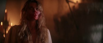 Movie still from “The Monster Squad” (1987), directed by Fred Dekker – A woman with blood on her face is standing in front of a wall; Close Up shot, Over the shoulder angle