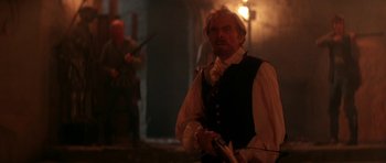 Movie still from “The Monster Squad” (1987), directed by Fred Dekker – A man in a black shirt and a white beard; Medium shot, Over the shoulder angle