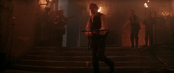 Movie still from “The Monster Squad” (1987), directed by Fred Dekker – A man holding a sword walking down a set of stairs; Wide shot, Low angle