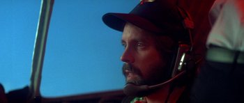 Movie still from “The Monster Squad” (1987), directed by Fred Dekker – A man with a beard wearing a baseball cap and a headset; Close Up shot, Low angle