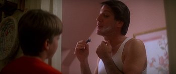 Movie still from “The Monster Squad” (1987), directed by Fred Dekker – A man shaving his face in the bathroom mirror; Close Up shot, Low angle