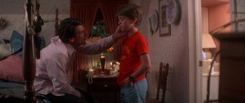 Movie still from “The Monster Squad” (1987), directed by Fred Dekker – A young boy being examined by an adult; Medium shot, Over the shoulder angle