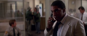 Movie still from “The Monster Squad” (1987), directed by Fred Dekker – A man talking on a cell phone in a room; Close Up shot, Over the shoulder angle