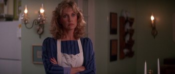 Movie still from “The Monster Squad” (1987), directed by Fred Dekker – A woman standing with her arms crossed in front of a wall; Close Up shot, Low angle