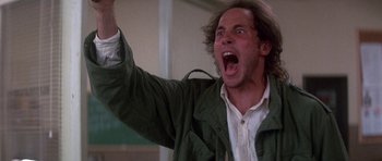 Movie still from “The Monster Squad” (1987), directed by Fred Dekker – A man in a green jacket is yelling with his mouth wide open; Medium shot, Low angle