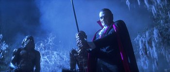 Movie still from “The Monster Squad” (1987), directed by Fred Dekker – A man dressed up as dracula holding a sword; Medium shot, Low angle