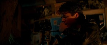 Movie still from “The Monster Squad” (1987), directed by Fred Dekker – A man smoking a cigarette in front of a microphone; Close Up shot, Over the shoulder angle