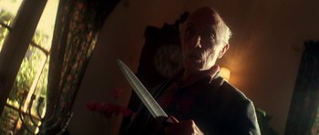 Movie still from “The Monster Squad” (1987), directed by Fred Dekker – An old man holding a knife in a room; Close Up shot, Low angle