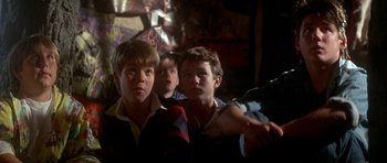 Movie still from “The Monster Squad” (1987), directed by Fred Dekker – A group of young men standing next to each other in a room; Close Up shot, Low angle