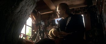 Movie still from “The Monster Squad” (1987), directed by Fred Dekker – A man holding a ball in his hands while standing in a room; Medium shot, Low angle