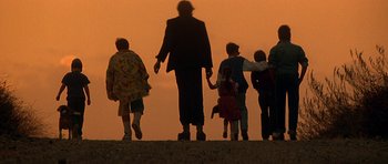 Movie still from “The Monster Squad” (1987), directed by Fred Dekker – A group of people walking on the beach at sunset; Wide shot, Low angle