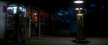 Movie still from “The Monster Squad” (1987), directed by Fred Dekker – An empty parking lot at night with trees in the background; Wide shot, High angle