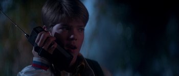 Movie still from “The Monster Squad” (1987), directed by Fred Dekker – A young man talking on a cell phone in the dark; Close Up shot, Low angle