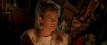 Movie still from “The Monster Squad” (1987), directed by Fred Dekker – A woman with long blonde hair wearing a white shirt; Close Up shot, Over the shoulder angle