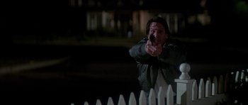 Movie still from “The Monster Squad” (1987), directed by Fred Dekker – A man pointing a gun at the camera; Medium shot, Low angle