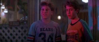 Movie still from “The Monster Squad” (1987), directed by Fred Dekker – Two young men standing next to each other in front of a window at night; Medium shot, Low angle